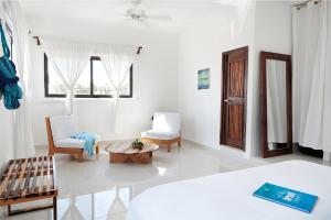 a white room with a bed and a table and chairs at Casa el Pio in Isla Mujeres