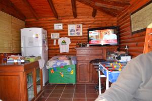 a kitchen with a tv in a wooden cabin at Las Esmeraldas in Nono