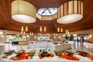 ein Bankettsaal mit weißen Tischen und Kronleuchtern in der Unterkunft Aguativa Golf Resort in Cornélio Procópio