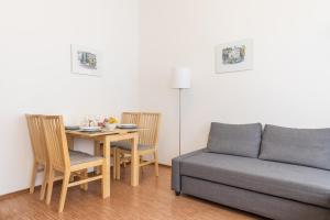 - un salon avec un canapé et une table avec des chaises dans l'établissement Paradise Apartment, à Prague
