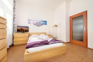 - une chambre avec un lit et une porte en bois dans l'établissement Paradise Apartment, à Prague