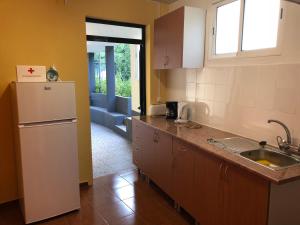 a kitchen with a white refrigerator and a sink at Casa da Igreja in Santana
