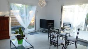 a living room with a table and chairs and a television at Le gîte du golf in Montauban