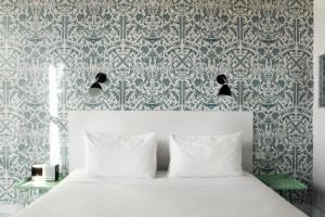 a bedroom with a bed with a blue and white wallpaper at Wythe Hotel in Brooklyn