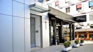 a facade of a building with potted plants on a sidewalk at Haris Apartment Tirana no.2 in Tirana