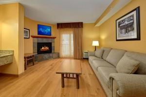 a living room filled with furniture and a fireplace at Bearskin Lodge on the River in Gatlinburg