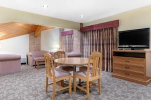 a living room with a table and chairs and a television at Quality Inn Washington Court House in Jeffersonville