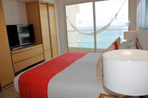 a bedroom with a bed with a television and a window at Hotel Irotama Reservado in Santa Marta