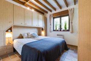 a bedroom with a blue bed and a window at La Belle du Bayehon in Malmedy