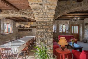 a living room with stone walls and a table and chairs at Villa Belle in Oprtalj