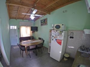 cocina con mesa y nevera blanca en Departamentos Chacabuco Familiar en Colón