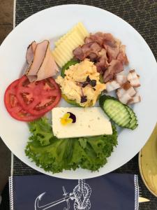 a plate of food with cheese and vegetables on a table at Hotel Edma in Alexandria