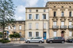 dos autos estacionados en un estacionamiento frente a un edificio en Studio Pont-Canal en Agen