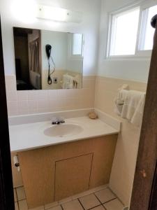uma casa de banho com um lavatório e um espelho em The Simplicity Inn em Marshfield
