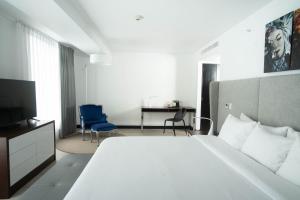 ein Schlafzimmer mit einem großen weißen Bett und einem Schreibtisch in der Unterkunft Radisson Hotel Decapolis Miraflores in Lima