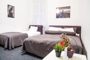 a bedroom with two beds and a table with flowers at Hearth of Belgrade apartment in Belgrade