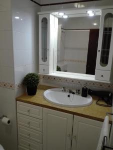 ファロにあるSea View urban apartmentの白い洗面台と鏡のあるバスルーム