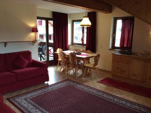 a living room with a table and a red couch at Residenze Sonnenschein Casa Bianca in Villabassa