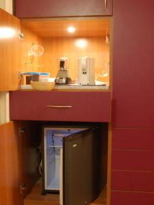 eine Küche mit einer roten Arbeitsplatte mit einem Gerät in der Unterkunft MiCasaTuCasa in Neapel