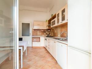 a kitchen with white cabinets and a sink and a table at Guesthouse Centar 2 in Zagreb