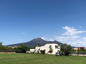 a white house with a car parked in a field at Dimora Santo Stefano in Pompei
