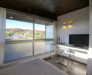 a bedroom with a desk and a large window at Dúplex 2 las Marías in San Salvador de Jujuy