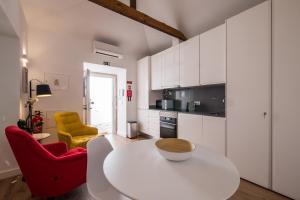 リスボンにあるSoul House - Exclusive Apartmentのキッチン(白いテーブル、赤い椅子2脚付)