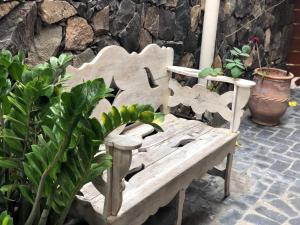 un banco de madera sentado en un patio con plantas en Caserío de la Playa - Adults Only en Valle Gran Rey