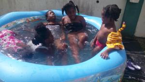 a group of children playing in a swimming pool at Little Palace BNB in Saint Georgeʼs