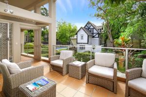 a patio with wicker chairs and a table at Alderly Apartment 11, Little Cove in Noosa Heads