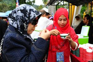 Dos mujeres en el hiyab comiendo comida de un tazón en Santika en Kampong Jawa