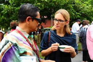 Eine Frau, die einen Mann sieht, der eine Tasse hält. in der Unterkunft Santika in Kampong Jawa