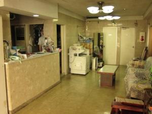 a room with a kitchen with a counter and a refrigerator at Aoi Business Hotel in Fukuyama