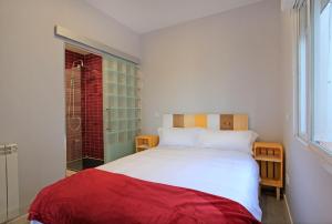 sypialnia z białym łóżkiem i oknem w obiekcie Mirador de Cervantes w mieście Toledo