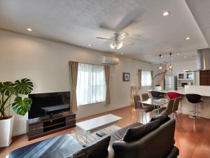 a living room with a couch and a tv at The Pool Resort Villa Hasta Manana in Onna