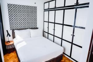 a bedroom with a white bed and a window at Parque España Residence Hotel Managed by HII in Manila