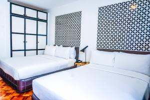 1 Schlafzimmer mit 2 Betten und einem Fenster in der Unterkunft Parque España Residence Hotel Managed by HII in Manila