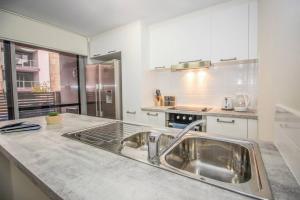 a kitchen with a sink and a counter top at The Happy Delightful Place - Entire 2 Room Apartment in Cockburn Central