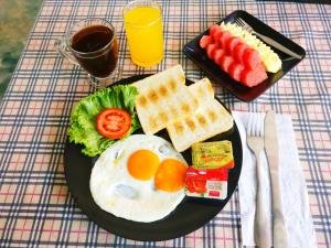 a plate of breakfast food with eggs and waffles and fruit at Sleep In Lanta Resort in Ko Lanta
