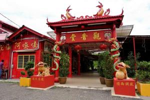 ein rotes Gebäude mit chinesischer Schrift darauf in der Unterkunft Hotel Sri Raub in Raub