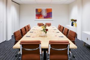 een grote vergaderzaal met een lange tafel en stoelen bij Art Series - The Watson in Adelaide
