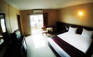 um quarto de hotel com uma cama e uma janela em Chiangkhong Green Inn Resident em Wiang Chiang Khong