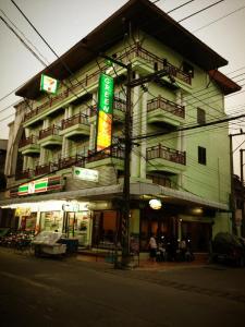 a building on a street corner next to a street at Chiangkhong Green Inn Resident in Chiang Khong