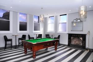 a billiard room with a pool table and a fireplace at The Stirling Arms Hotel in Perth