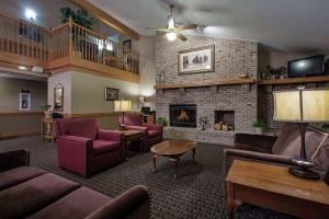 a lobby with couches chairs and a fireplace at AmericInn by Wyndham Grundy Center in Grundy Center
