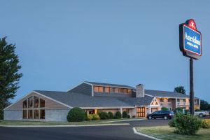 a large building with a sign in front of it at AmericInn by Wyndham Grundy Center in Grundy Center