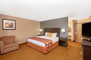 una habitación de hotel con una cama y un televisor en AmericInn by Wyndham Coralville, en Coralville