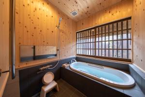 bagno con vasca, servizi igienici e finestra di こんぴら町家 Konpira Machiya a Kotohira