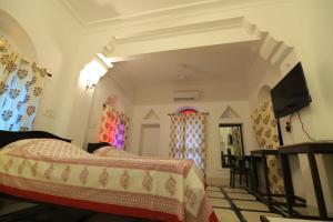 a bedroom with a bed and a flat screen tv at Chanod Haveli in Jodhpur