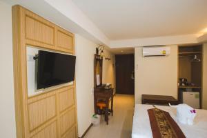 ein Hotelzimmer mit einem Fernseher an der Wand in der Unterkunft Chada Mantra Hotel in Chiang Mai